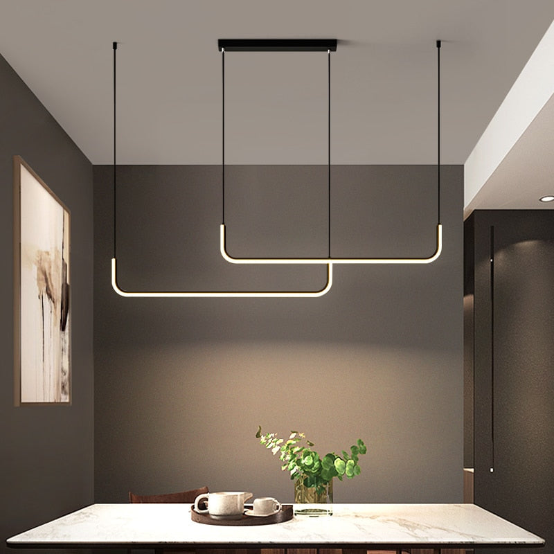 Arisha LED chandelier in gold and black, enhancing modern dining room aesthetics.