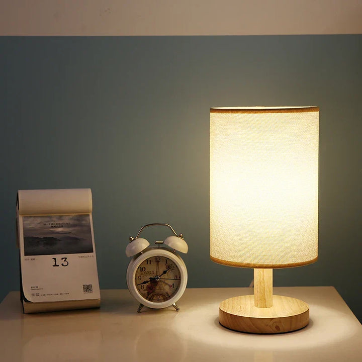 Natural wood table lamp with soft fabric shade. Dimmable LED, adjustable brightness for cozy spaces.