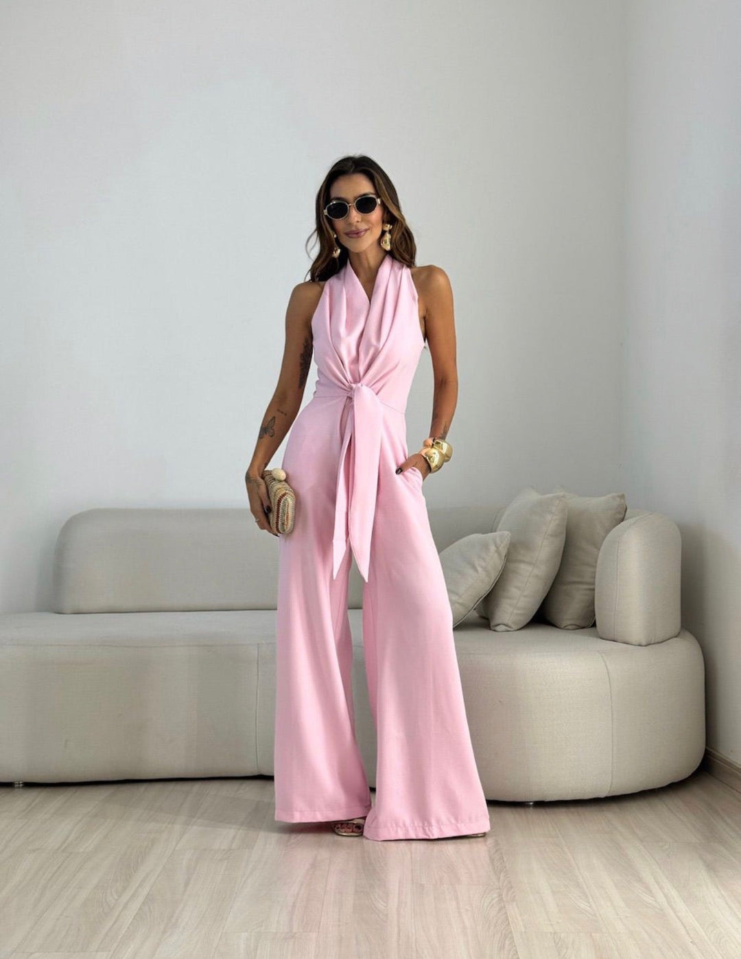 Model in elegant women's wide-leg halterneck jumpsuit, showcasing its flowing design.