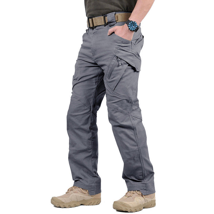 Man wearing durable tactical cargo pants outdoors, ready for hiking & adventure. Utility pockets visible.