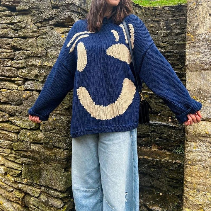 Soft, oversized women's smiley face cardigan sweater. Cozy knitwear for trendy fall and winter fashion looks.