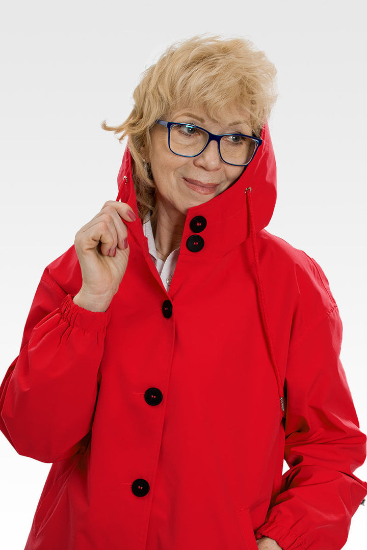 Woman wearing a black oversized hooded windbreaker, perfect for outdoor activities & fall fashion.