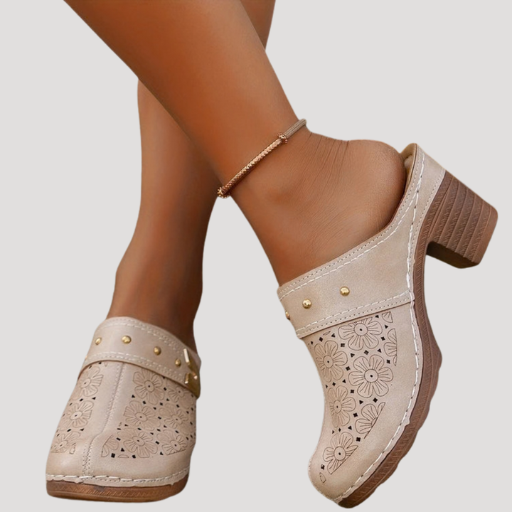 Women's slip-on clog mules with an embossed design, stable block heel, and stylish buckle detail.