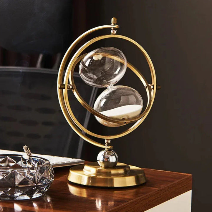 Decorative tabletop sand timer, features a sophisticated metal frame & clear glass hourglass.