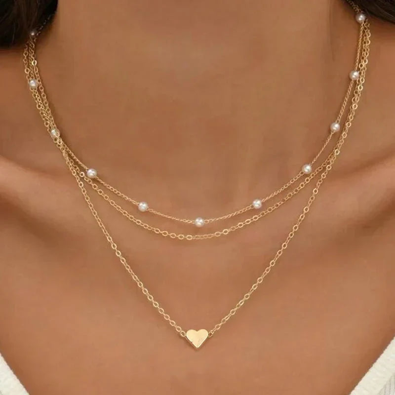 Women's triple layer necklace with elegant heart or cross pendant. Gold/silver layered fashion jewelry.