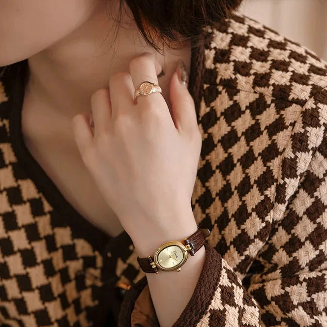 Close-up of elegant women's gold-tone quartz watch, showcasing its classic round dial.