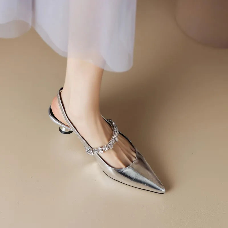 Elegant silver pointed pumps with crystal embellishments and a secure slingback strap, low heel.