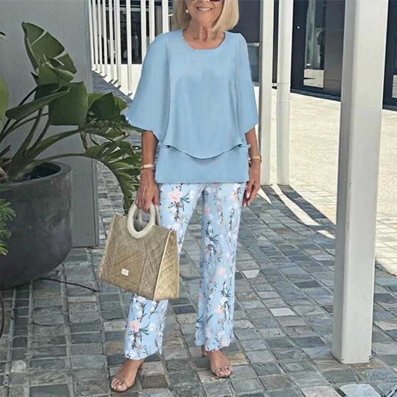 Stylish women's two-piece set: modern layered top paired with trendy leaf print pants for a sophisticated look.