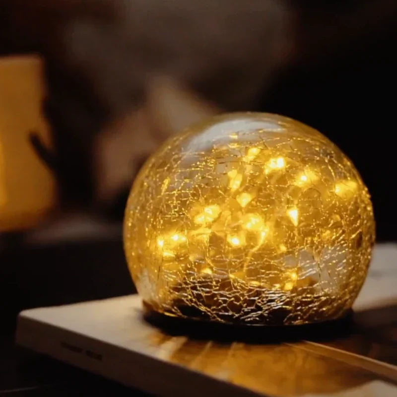 Elegant crackled glass solar orb garden light, warm white LED for beautiful outdoor decor.