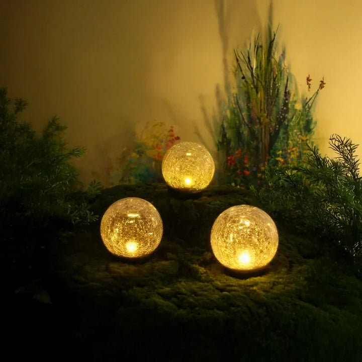 Waterproof solar-powered crackled glass orb LED light for garden & landscape decor.