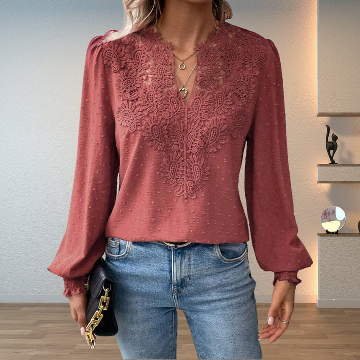 Women's fashion blouse with intricate lace bodice, long sleeves, and smocked cuffs. Elegant V-neck design.