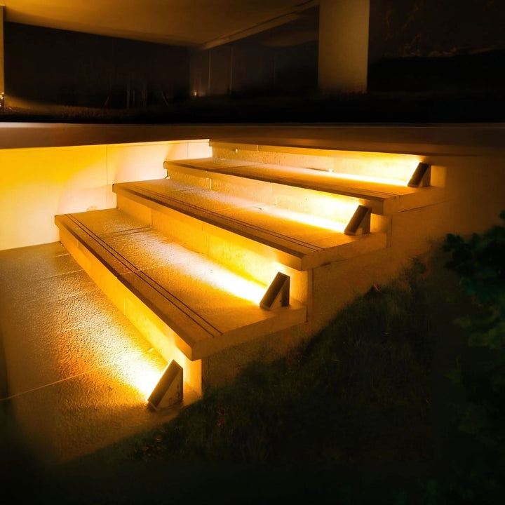 Solar pathway and stair lights illuminating a garden path next to steps, creating a cohesive outdoor lighting scheme.