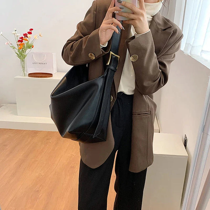 Black women's stylish slouchy faux leather shoulder tote bag, perfect for daily use.