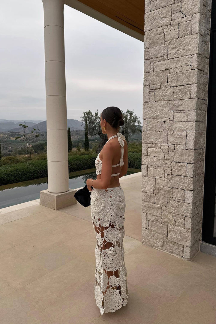 Women's white sleeveless maxi dress with stylish cut-outs and a halter neck for summer events.