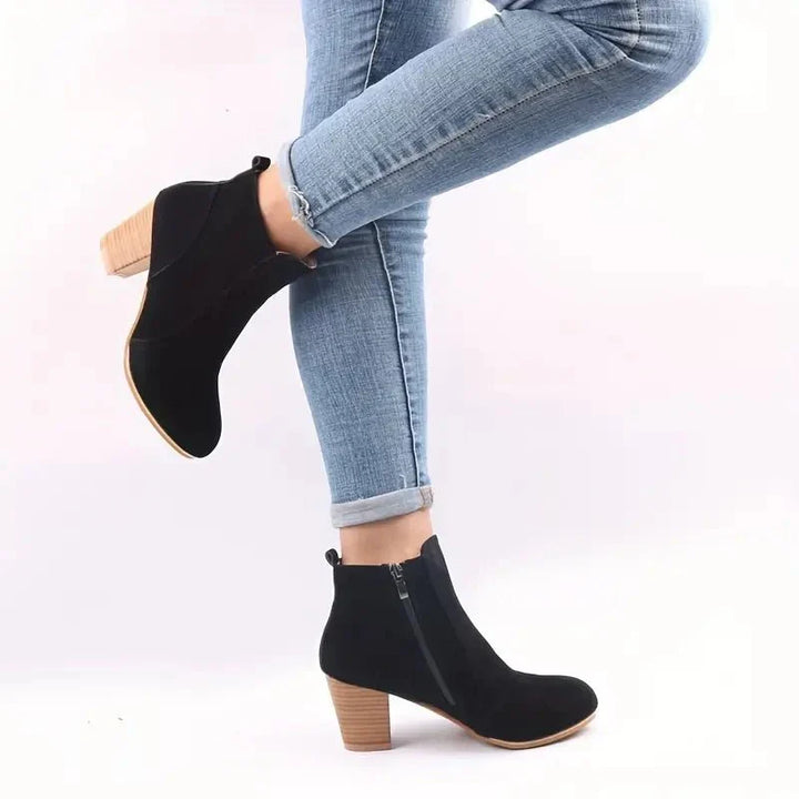 Close-up of a women's block heel ankle boot showcasing the chic side zip detail and sleek design.