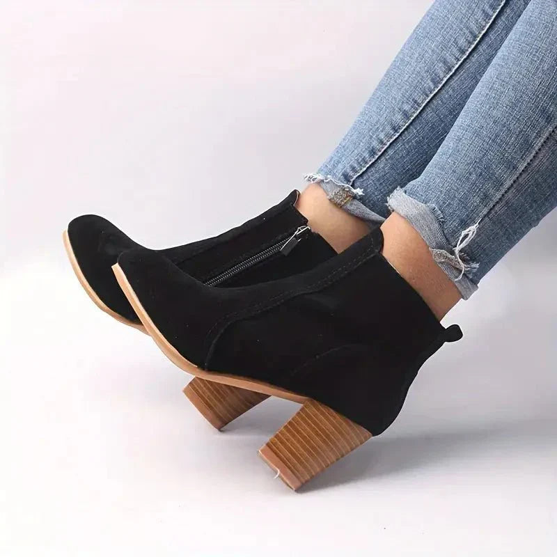 Women's chic black ankle boots with a prominent block heel, perfect for both casual and dressy outfits.