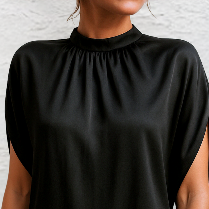 Close-up of a sophisticated black cap sleeve mini dress, showcasing its elegant high neck design.