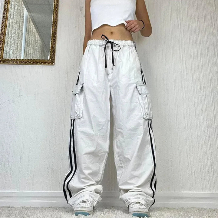 Women's baggy wide leg cargo pants with stylish side stripe and multiple utility pockets. Perfect for street style.