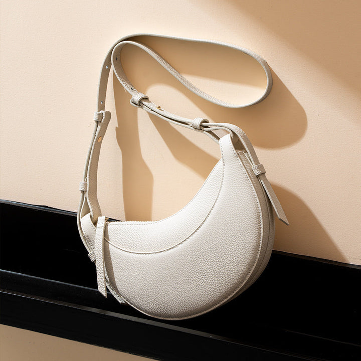 Chic women's crescent crossbody bag, modern design, pebbled texture, adjustable strap & reliable zip closure.