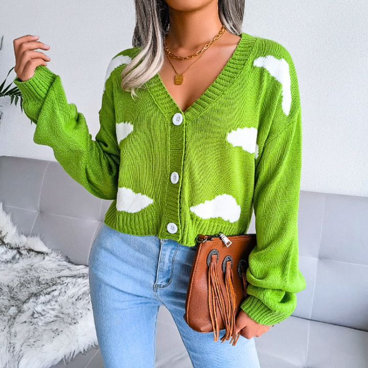 Model wearing women's cropped V-neck cloud print cardigan, buttoned. Casual spring fashion, light layer.