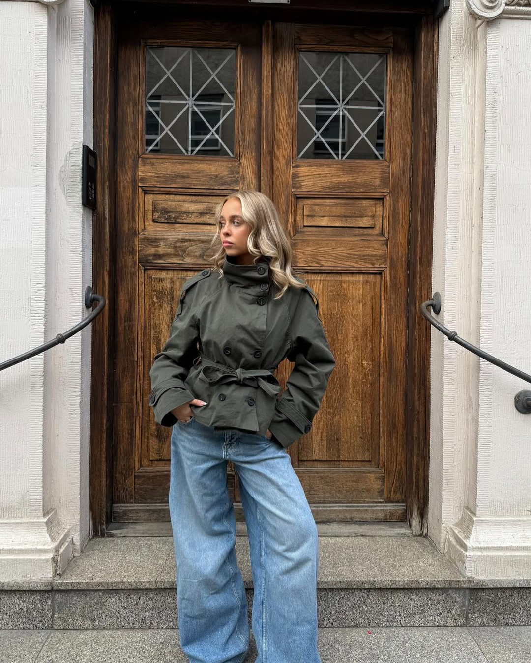 Fashionable women's cropped trench coat, double-breasted with belt, perfect for chic layering.