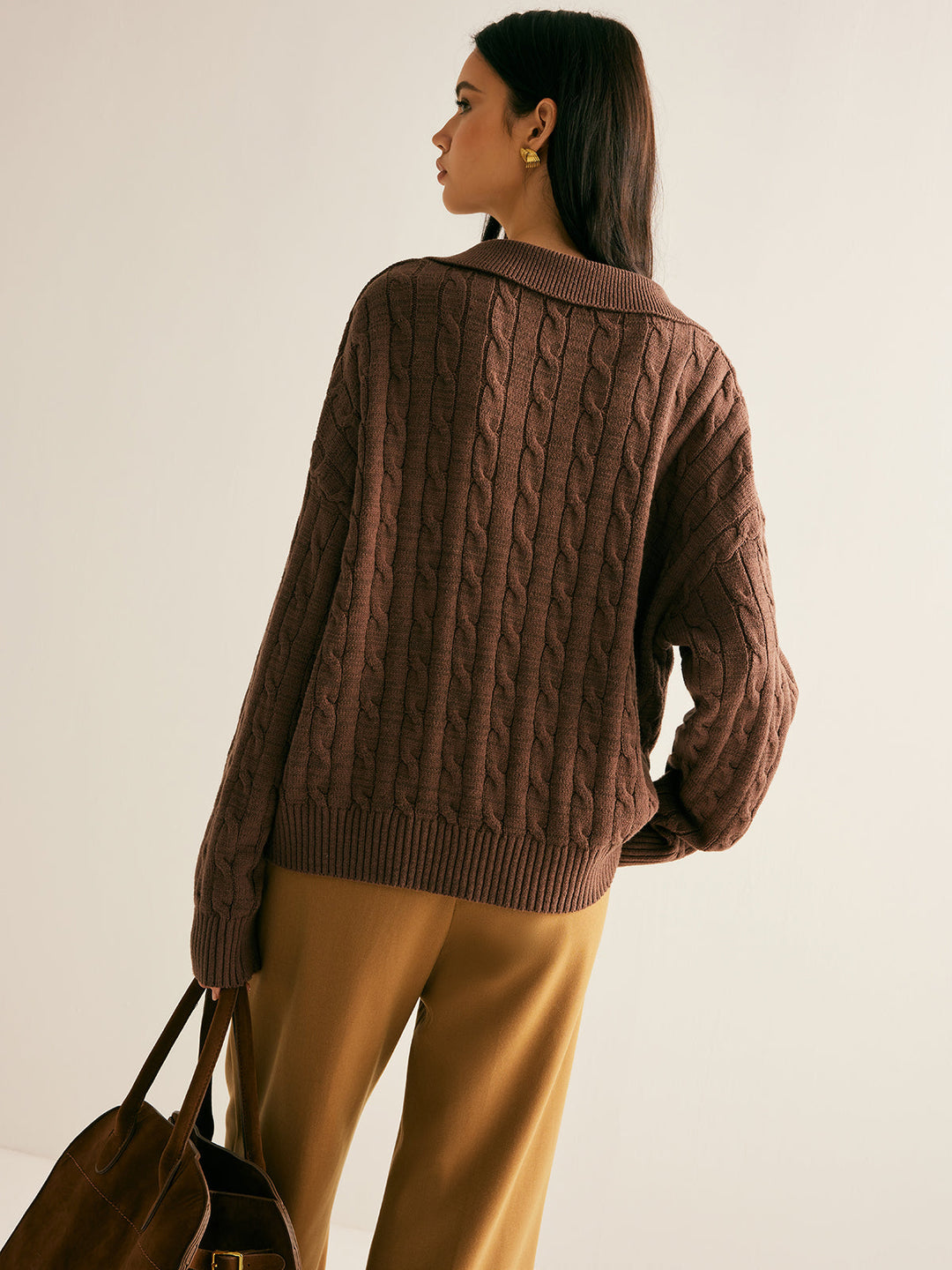 Oversized women's cable knit sweater featuring a stylish collared V-neck, drop shoulder, & cozy knit.