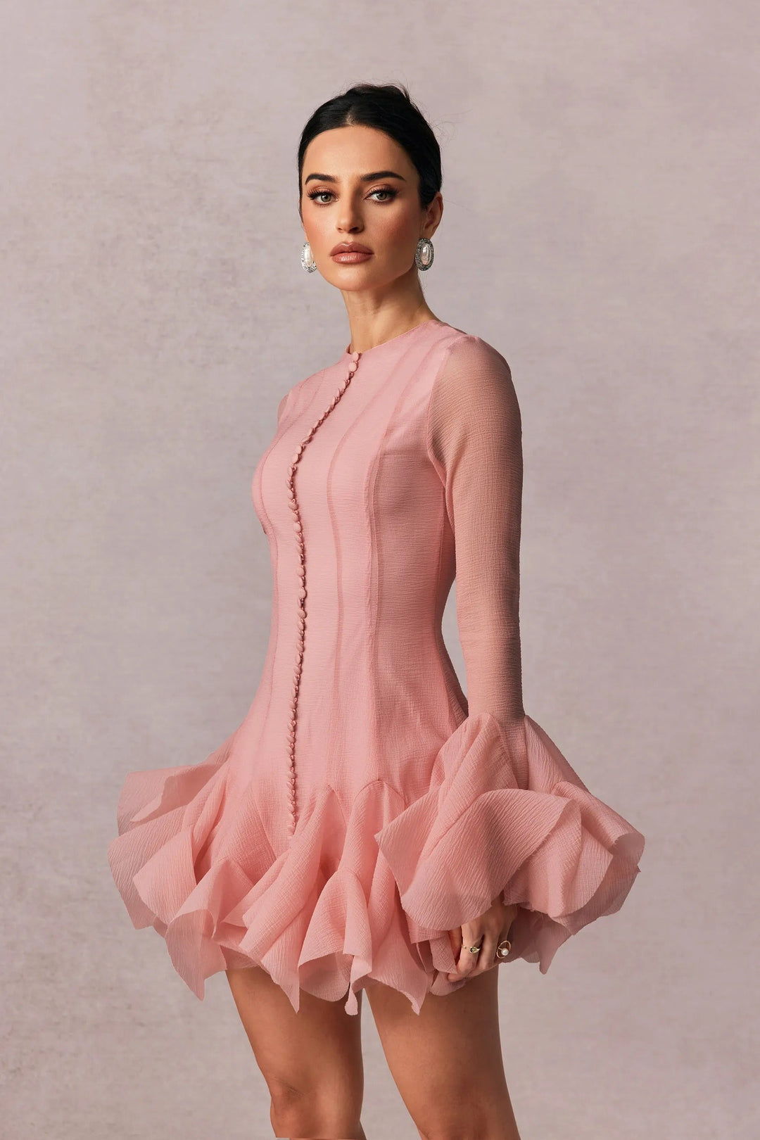 Chic women's pink long sleeve mini dress featuring playful ruffles, perfect for evening events.