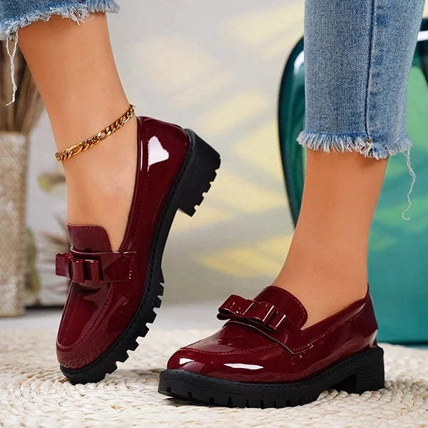 Stylish red platform loafers for women, with a chic bow accent and comfortable design.