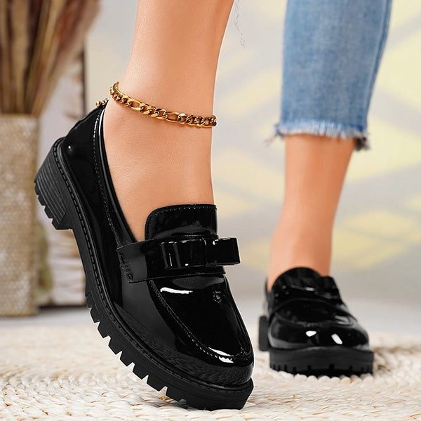 Chic black women's platform loafers with an elegant bow detail, perfect for versatile wear.