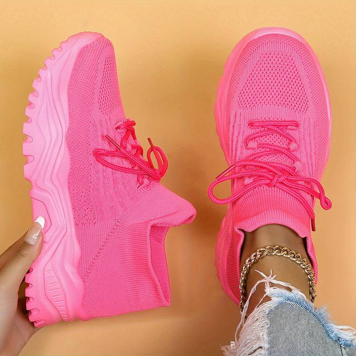Pink women's platform running sneakers, offering athletic style, grip & comfort for modern casual looks.