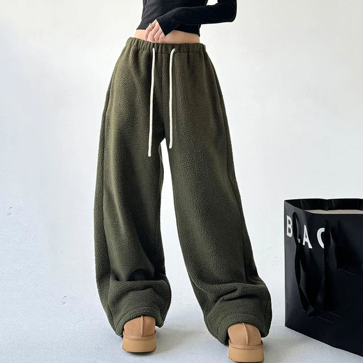 Model wearing women's high waist wide leg baggy sweatpants, showing relaxed fit and side seam detail.