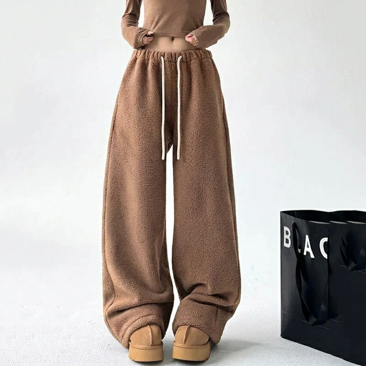 Folded women's high waist wide leg baggy sweatpants, showcasing the soft fabric & drawstring detail. Comfy loungewear.
