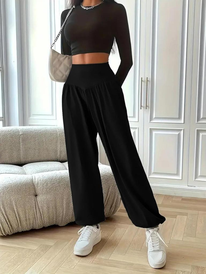 Woman in comfortable black high waist baggy sweatpants, perfect for relaxing or casual outings.