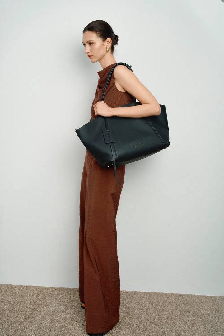 Durable black women's spacious everyday travel tote bag, showcasing sturdy straps & material.