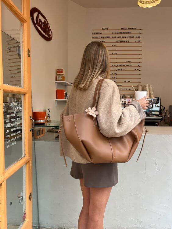 Woman carrying stylish brown large work tote bag, perfect for her professional outfit.