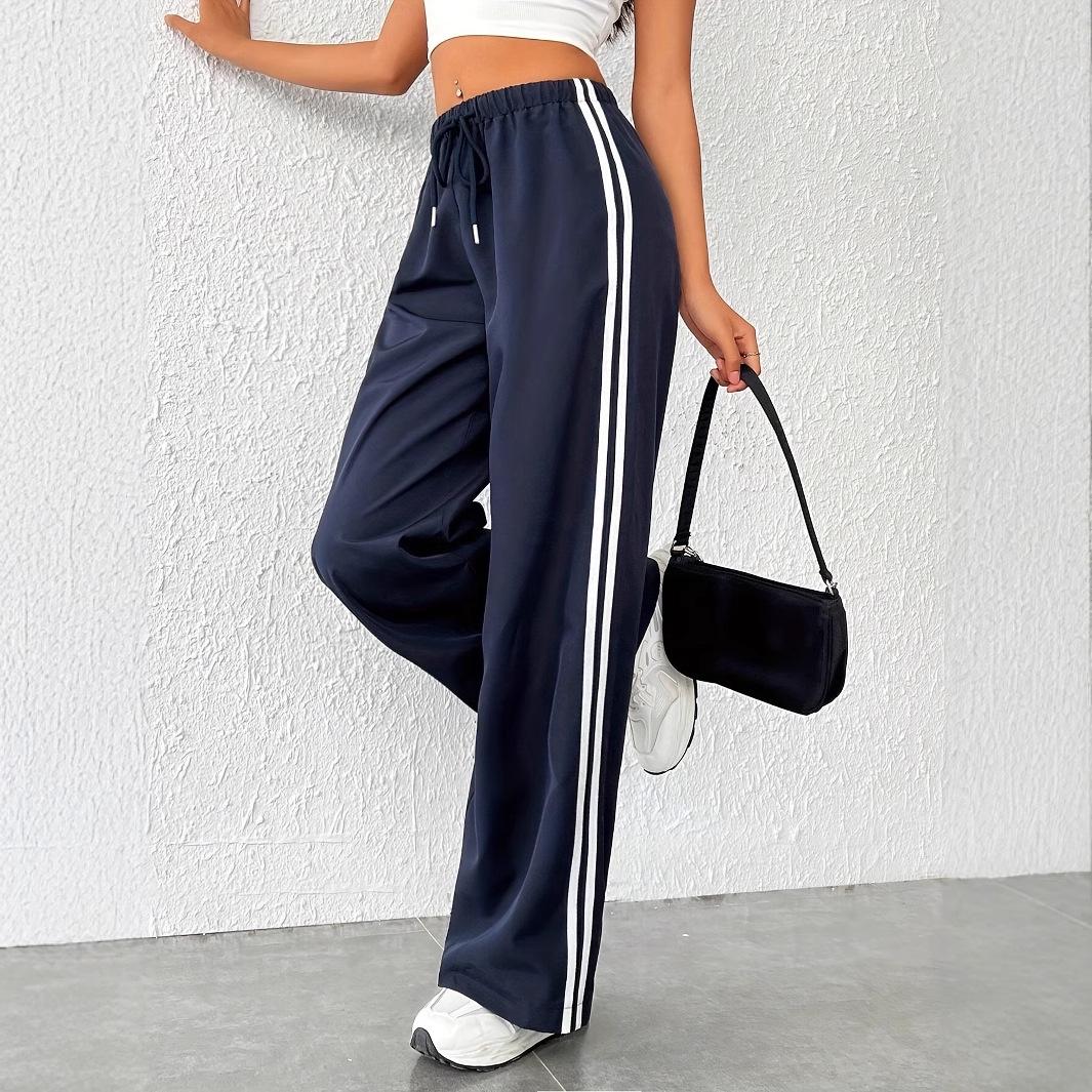 Dark blue women's wide leg track pants, palazzo fit, with a contrasting white side stripe. Elastic waist.