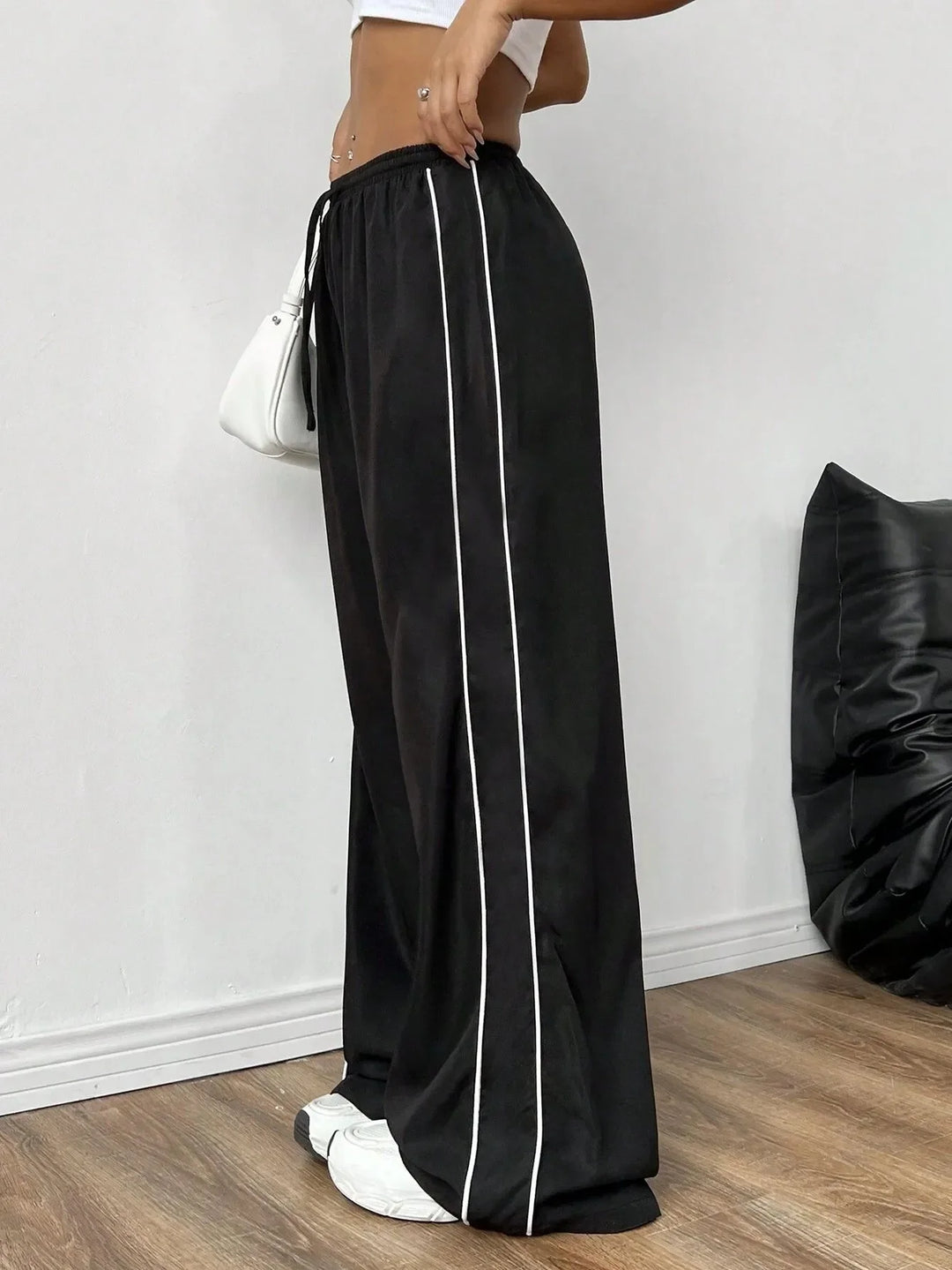 Versatile women's baggy trackpants, ideal for street style or active athleisure, with drawstring & piping.