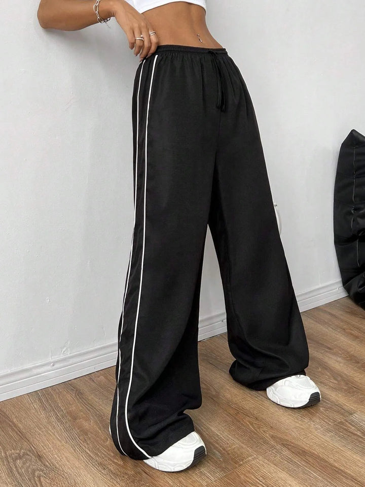 Trendy women's loose fit trackpants with a comfortable drawstring waist and chic side piping for everyday.