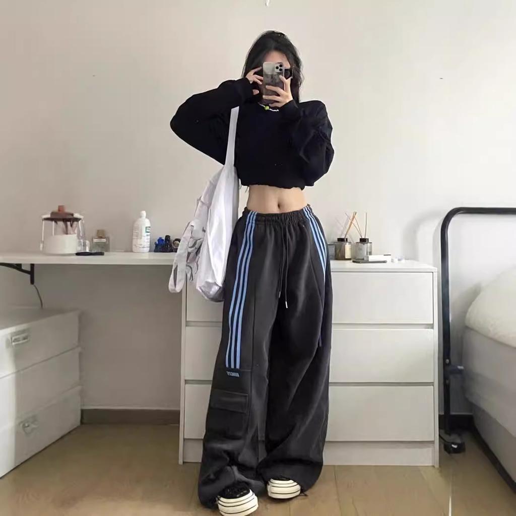 Comfortable oversized women's trackpants, featuring a Y2K baggy fit, side stripes, and practical cargo pockets.