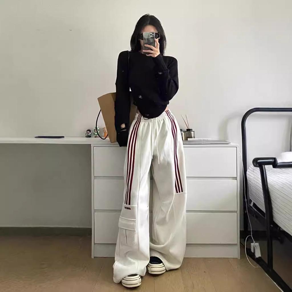 Oversized women's baggy trackpants, featuring side stripes and cargo pockets, ideal for a comfortable, casual style.