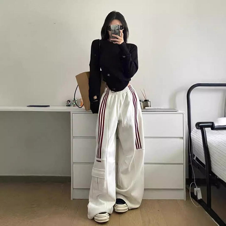 Oversized women's baggy trackpants, featuring side stripes and cargo pockets, ideal for a comfortable, casual style.
