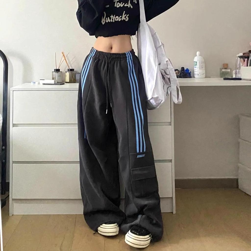 Women's baggy trackpants with stylish side stripes and functional cargo pockets, perfect for streetwear.