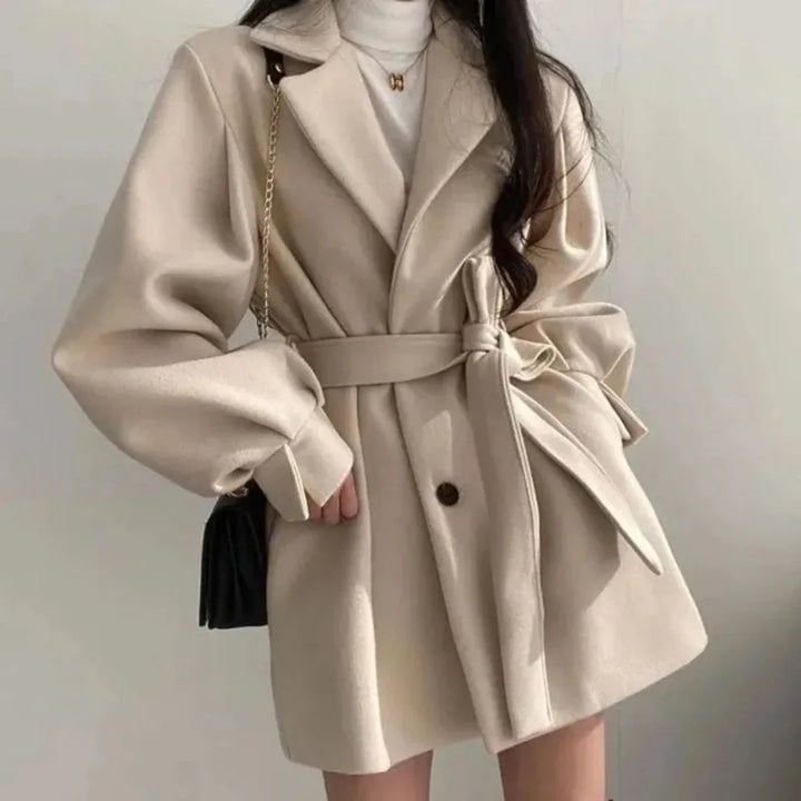 Black women's oversized trench coat, featuring wide lapel, belt & chic puff sleeves. Smart casual outerwear.