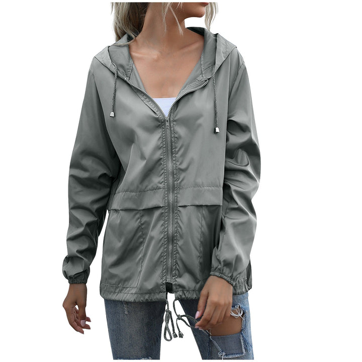 Lightweight women's windbreaker with hood, ideal for casual layering. Durable zip jacket for versatile outdoor wear.