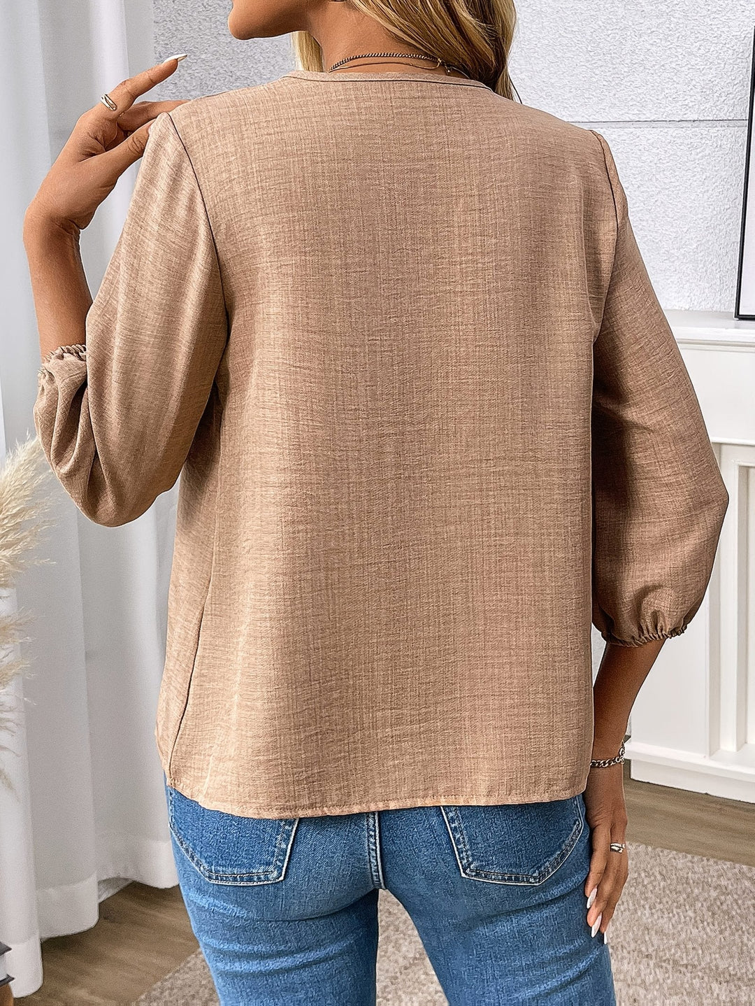 Chic women's V-neck blouse, elegant zip-front design. Three-quarter sleeve top, perfect for sophisticated fashion.