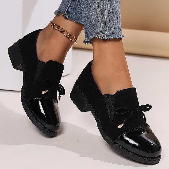 Elegant black women's loafers with a chic bow detail, perfect for everyday comfort and classic style.