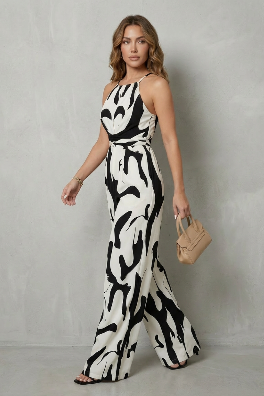 Back view of a chic women's halter wide-leg jumpsuit, showcasing the elegant abstract print and open back.