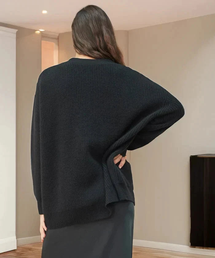 Woman wearing a black oversized knit cardigan vest, styled for a chic and relaxed look.