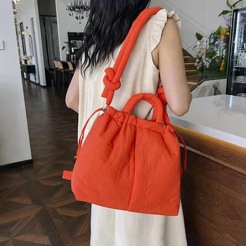 Model carrying the beige quilted puffer tote bag, showing scale