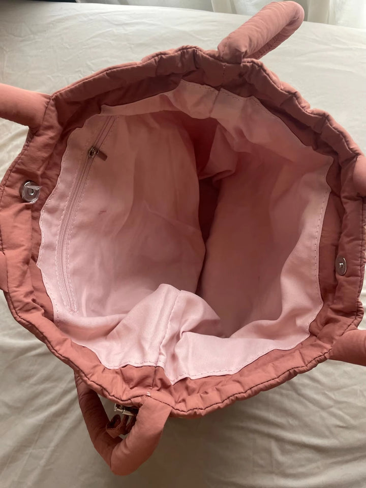 Side profile of the beige quilted puffer tote bag